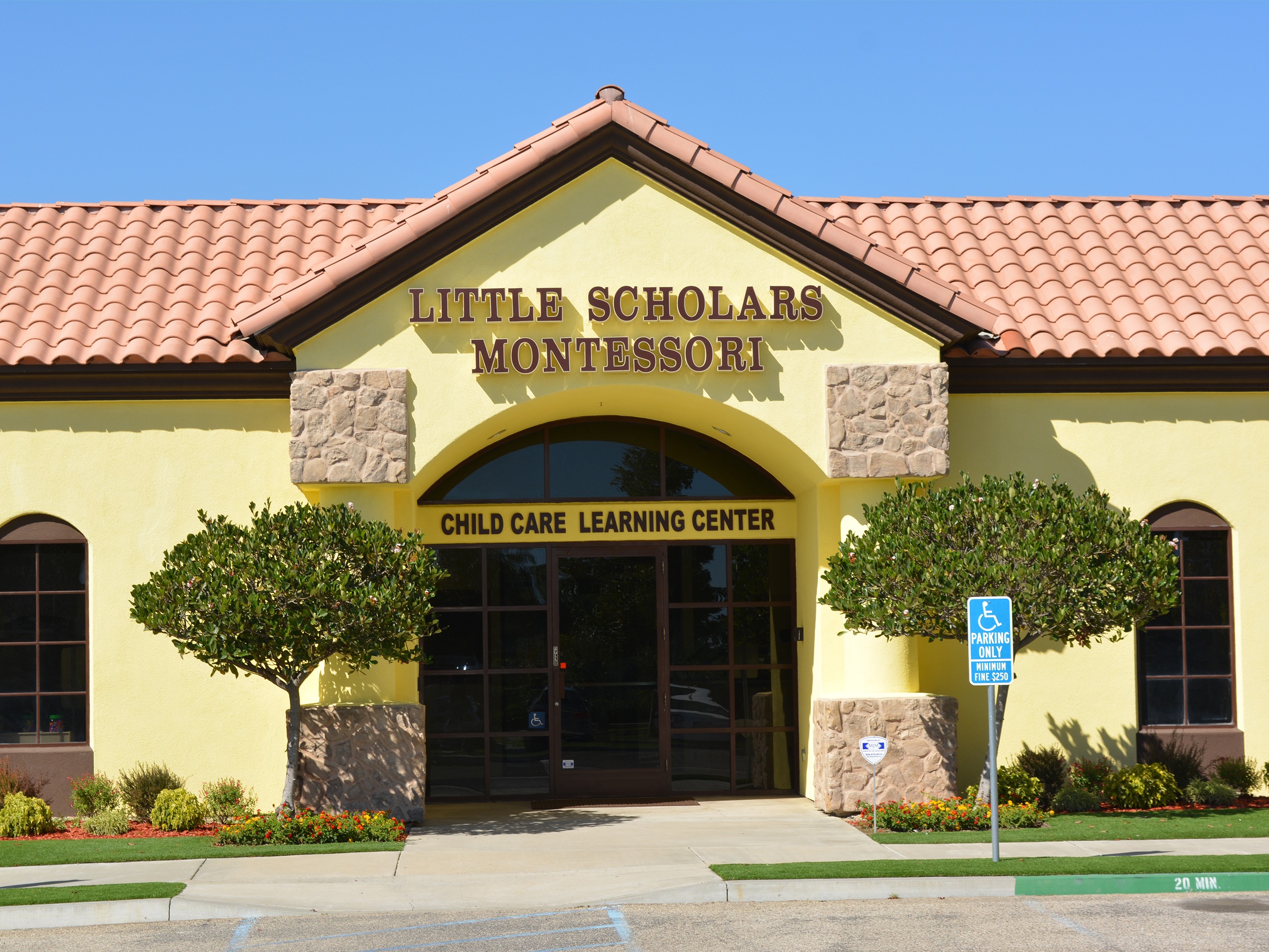 Front view of a building with a sign reading "Little Scholars Montessori Child Care Learning Center"