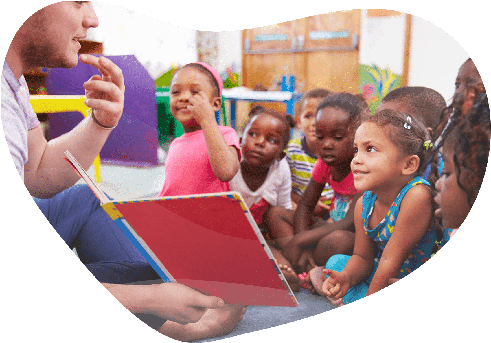 Volunteer teacher reading to a class of preschool kids